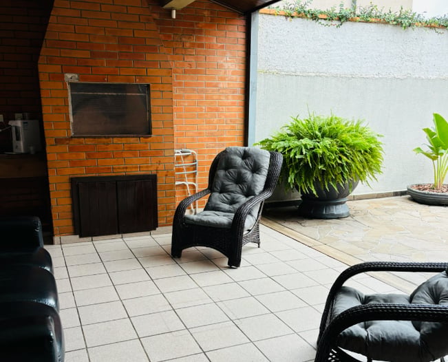 Varanda coberta com poltronas confortáveis e plantas